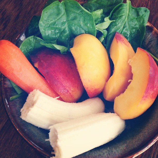 an apple, lettuce and carrots are arranged on a plate