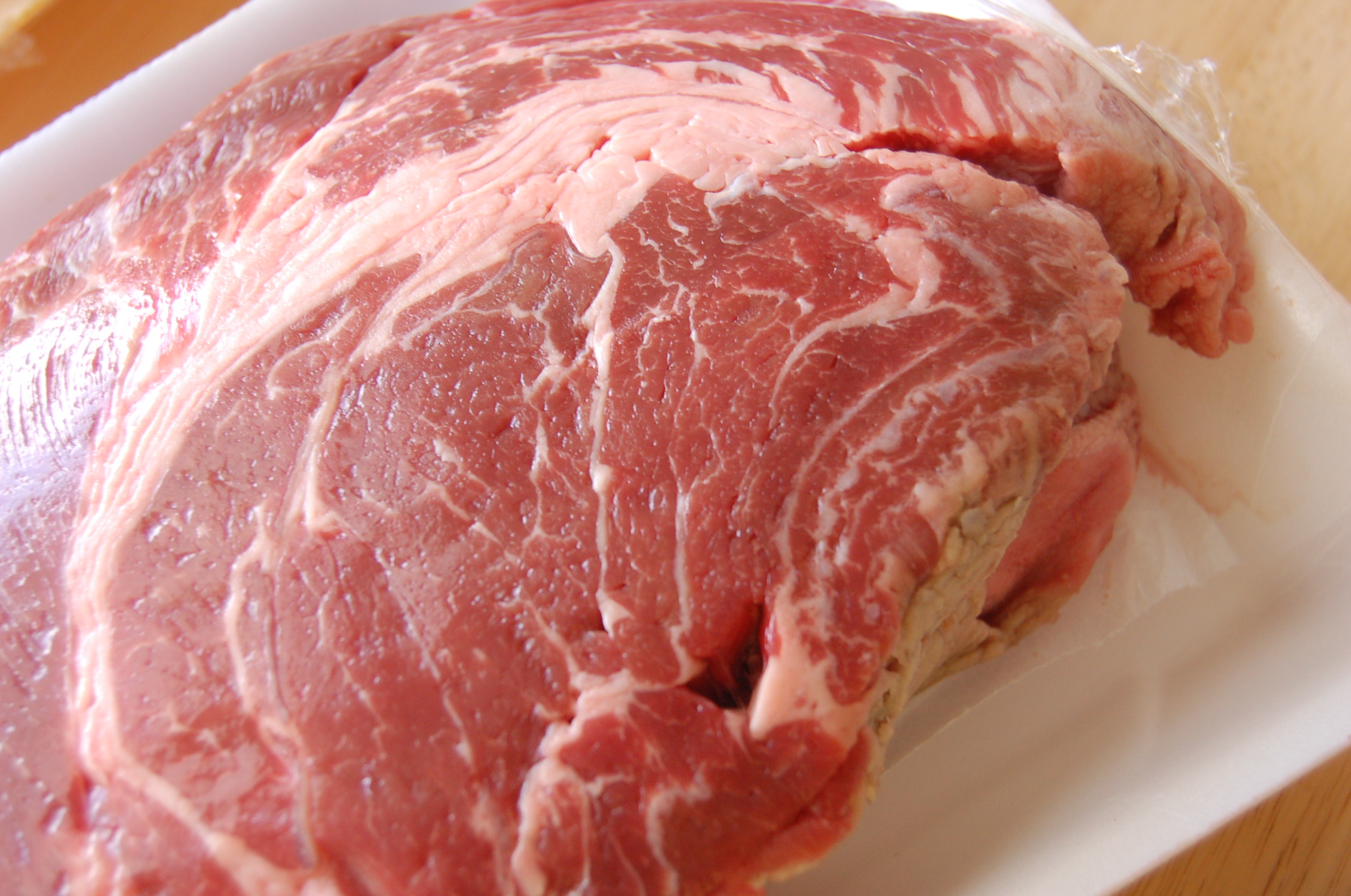 raw meat wrapped up and laying on top of a plastic container