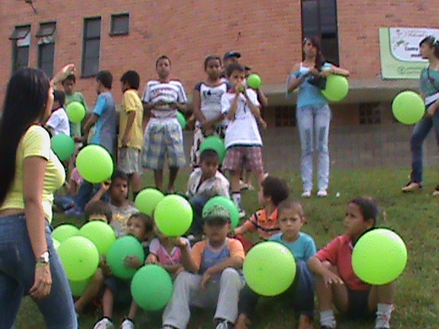 a group of children in grassy area playing with a frisbee