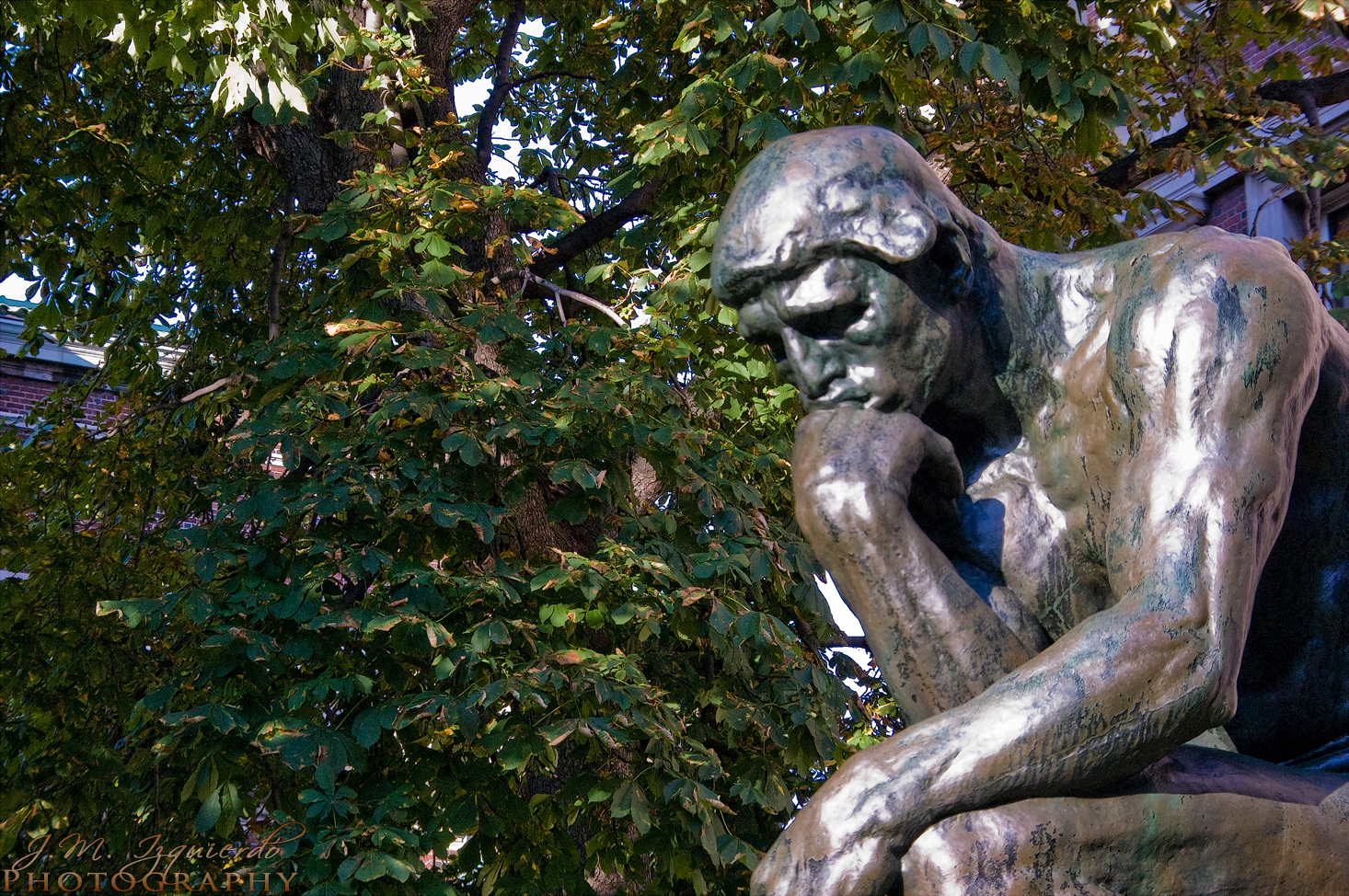 a statue of a seated man rests his head in his hands