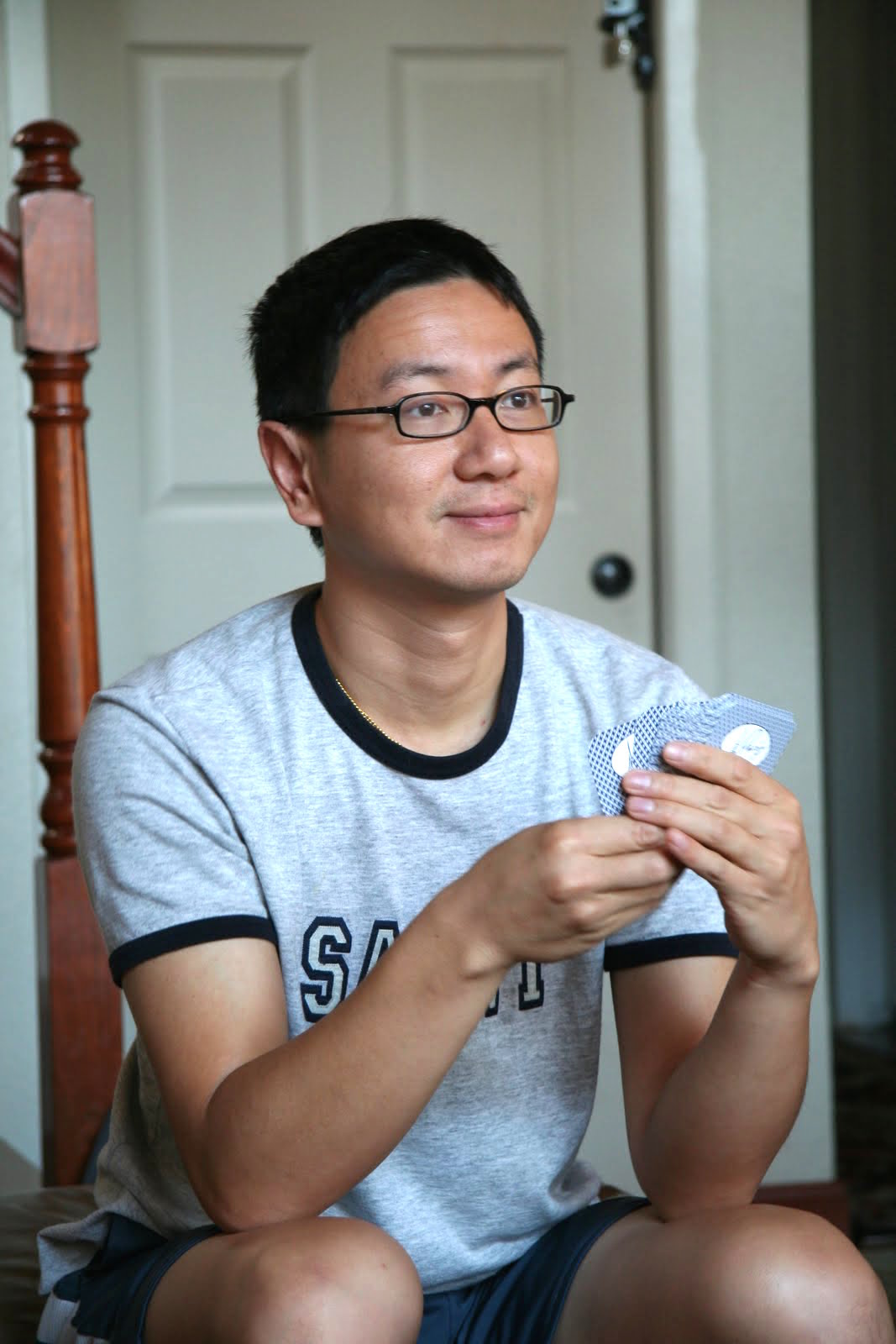 a man is sitting on the floor holding up some cards