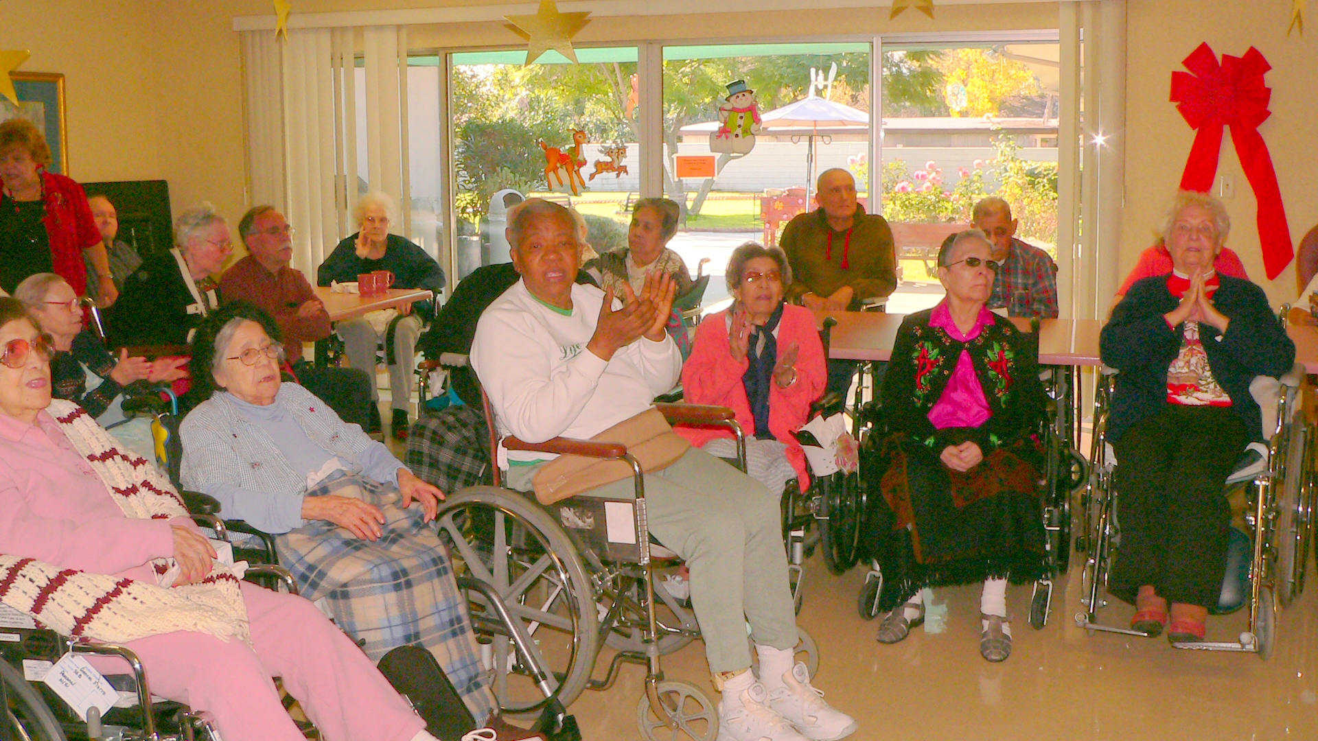 some people are sitting in chairs together in a room with yellow walls and red ribbons