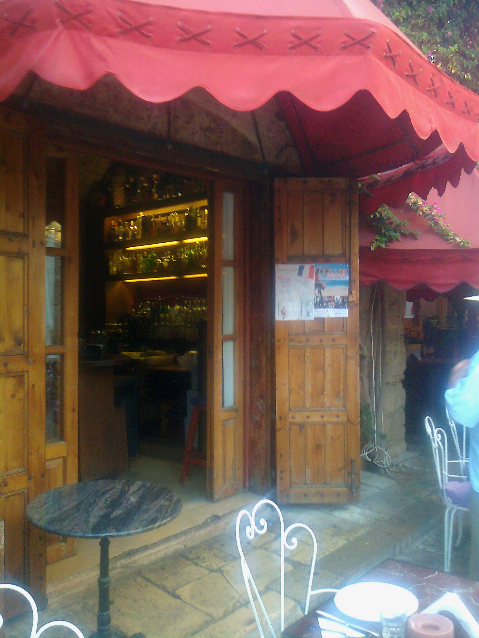 a table sitting outside of a building under a red awning