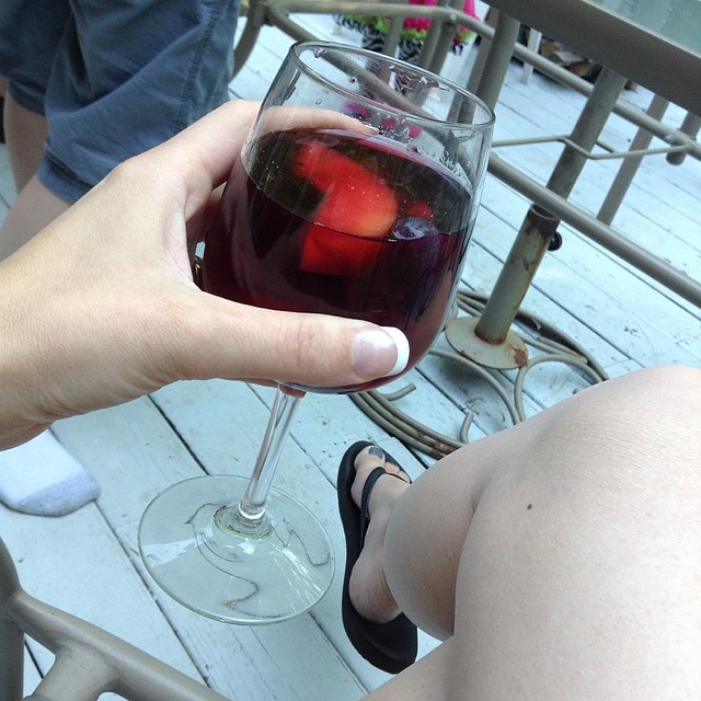 a woman holds a glass of wine on the balcony