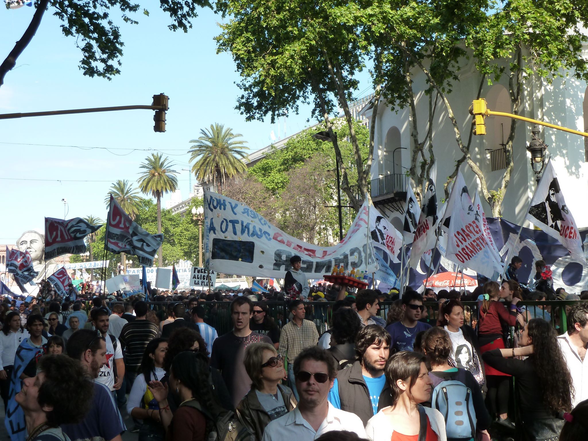 a large crowd of people standing next to a traffic light