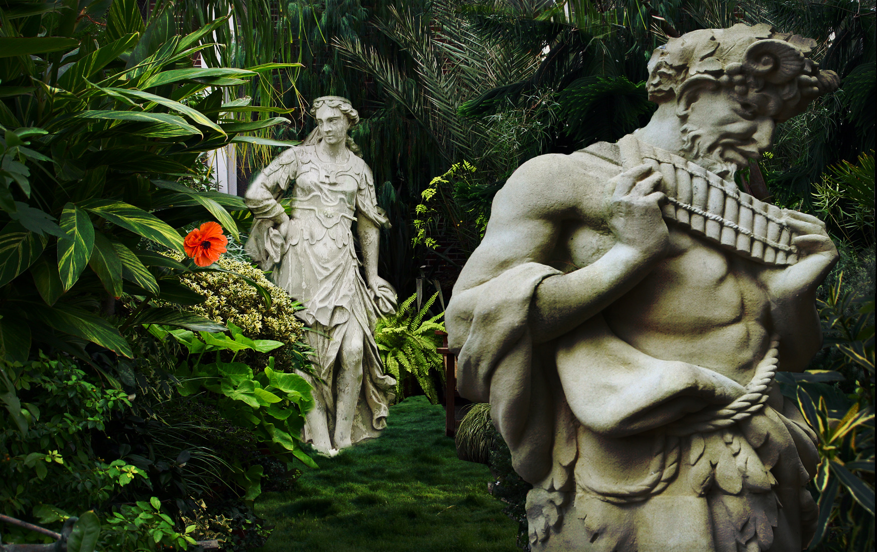 two statues stand in the grass with some vegetation