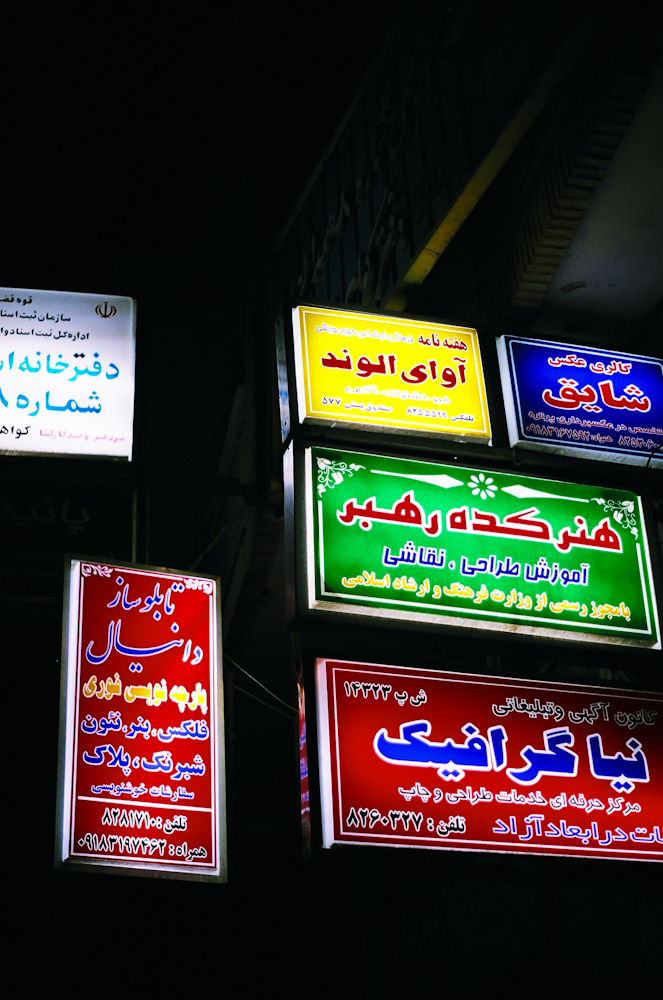 signs lit up in different colors for businesses