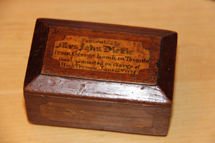 an old wooden box with a wooden plaque on top
