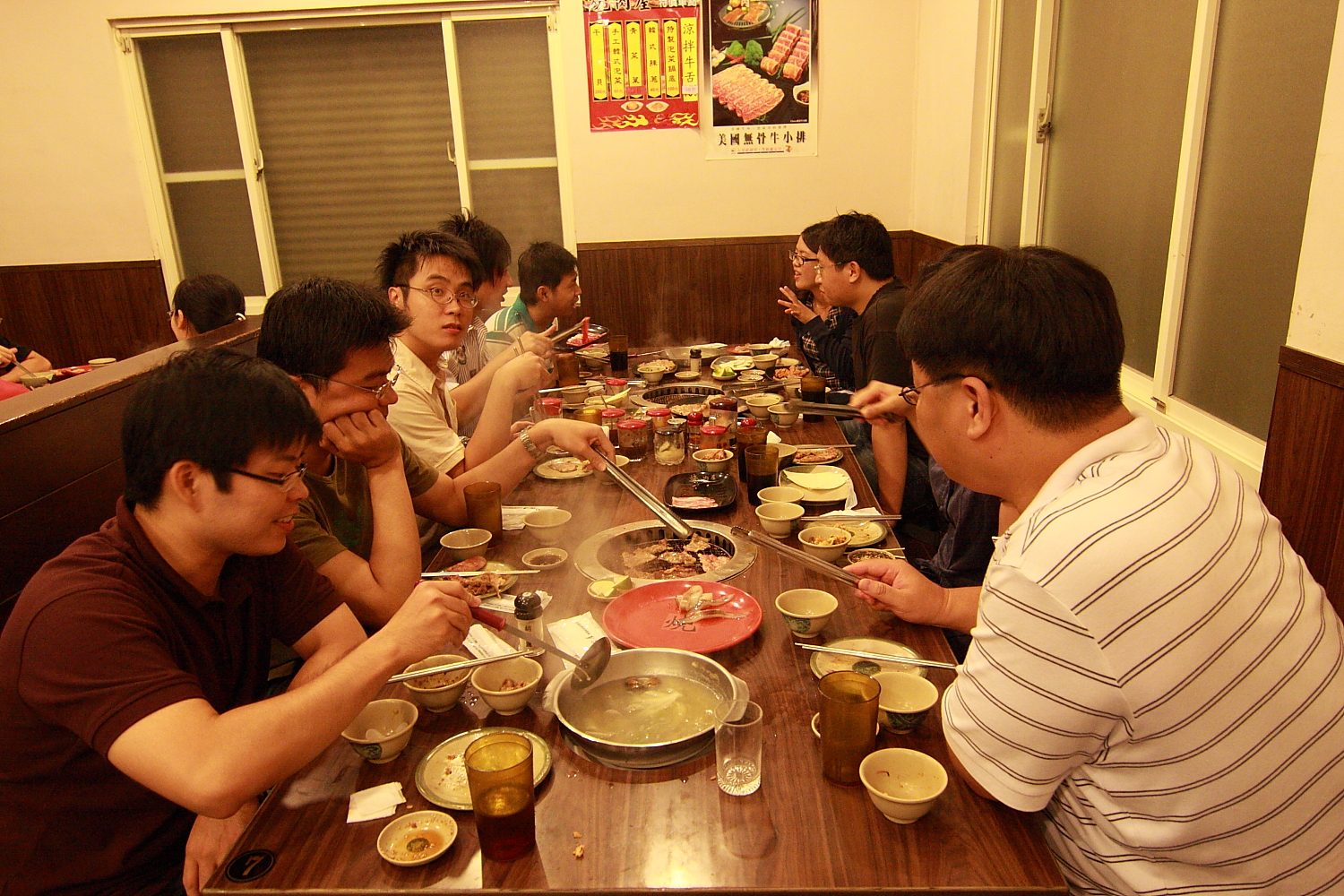 a group of people sitting around a long table eating