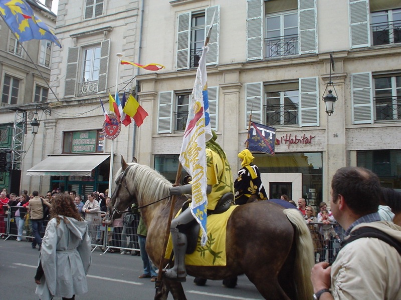 a crowd is watching a parade in an urban area