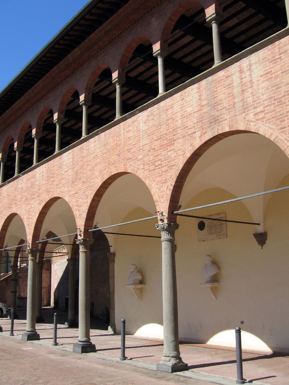 a brick building with arches, lights and water pipes