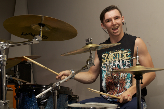 a man sitting down behind drums for soing