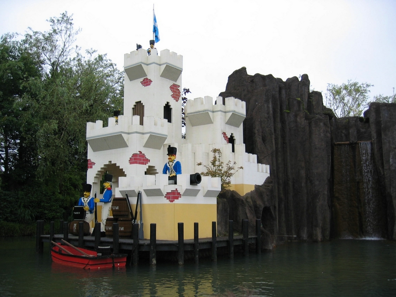 a floating castle sits near water with wooden pier