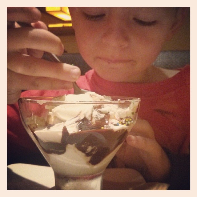 a young child is eating dessert in a dessert bowl