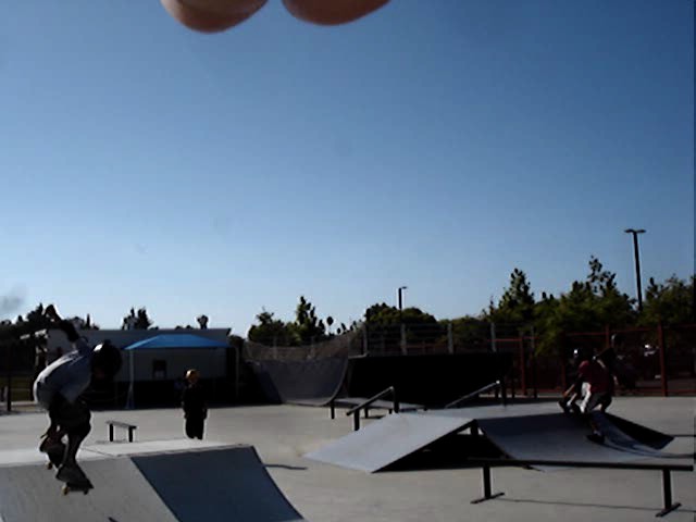 people skate boarding on ramps with the sky above them