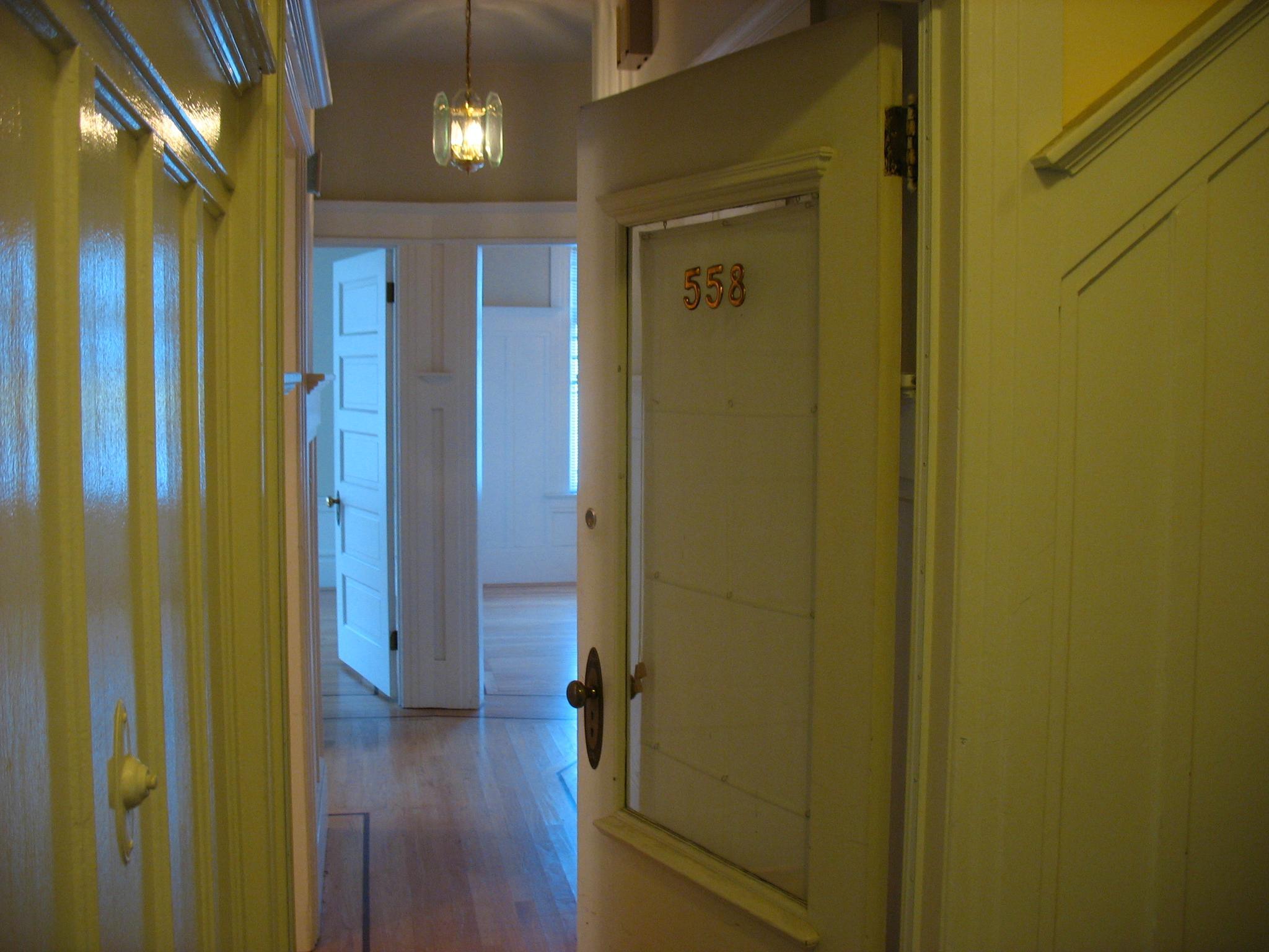 a house hallway with yellow painted walls and white doors