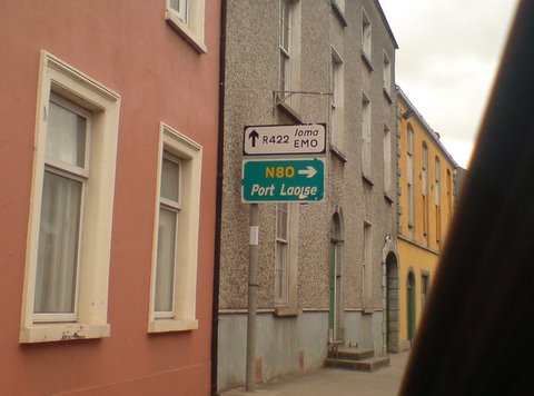 a green street sign in a narrow city