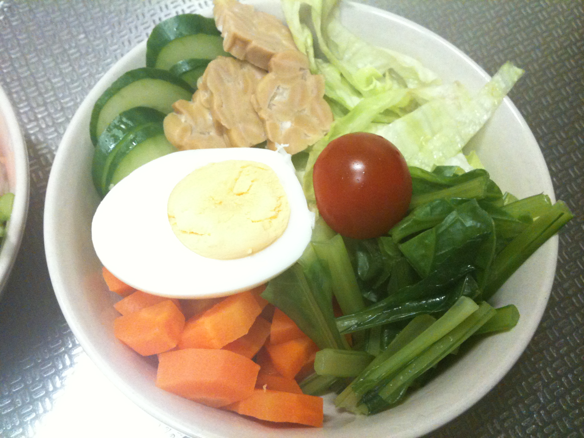 there is salad with some veggies and an egg on it