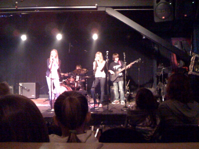 group of people in front of stage playing with microphone