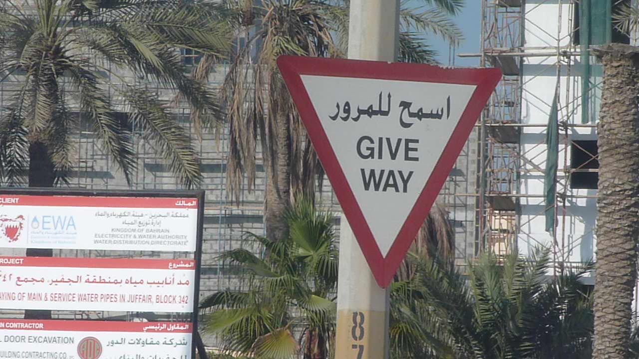 a sign on the side of a road points in two directions
