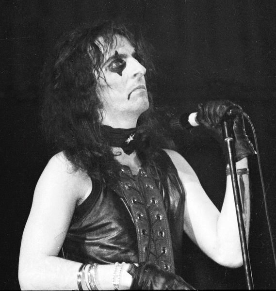 a person wearing black gloves and holding a microphone