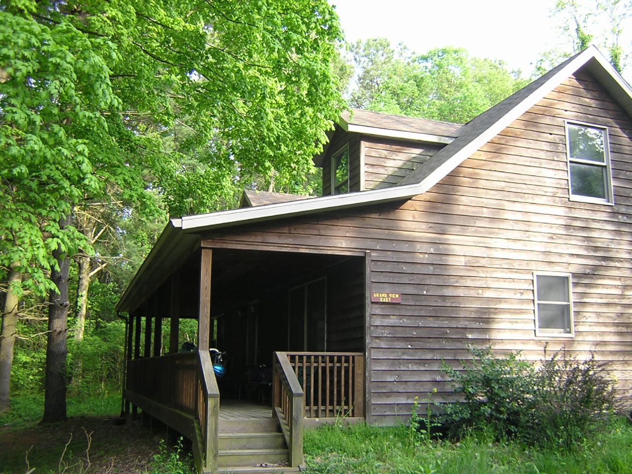 a wooden cabin with stairs leading into it and an outside deck area