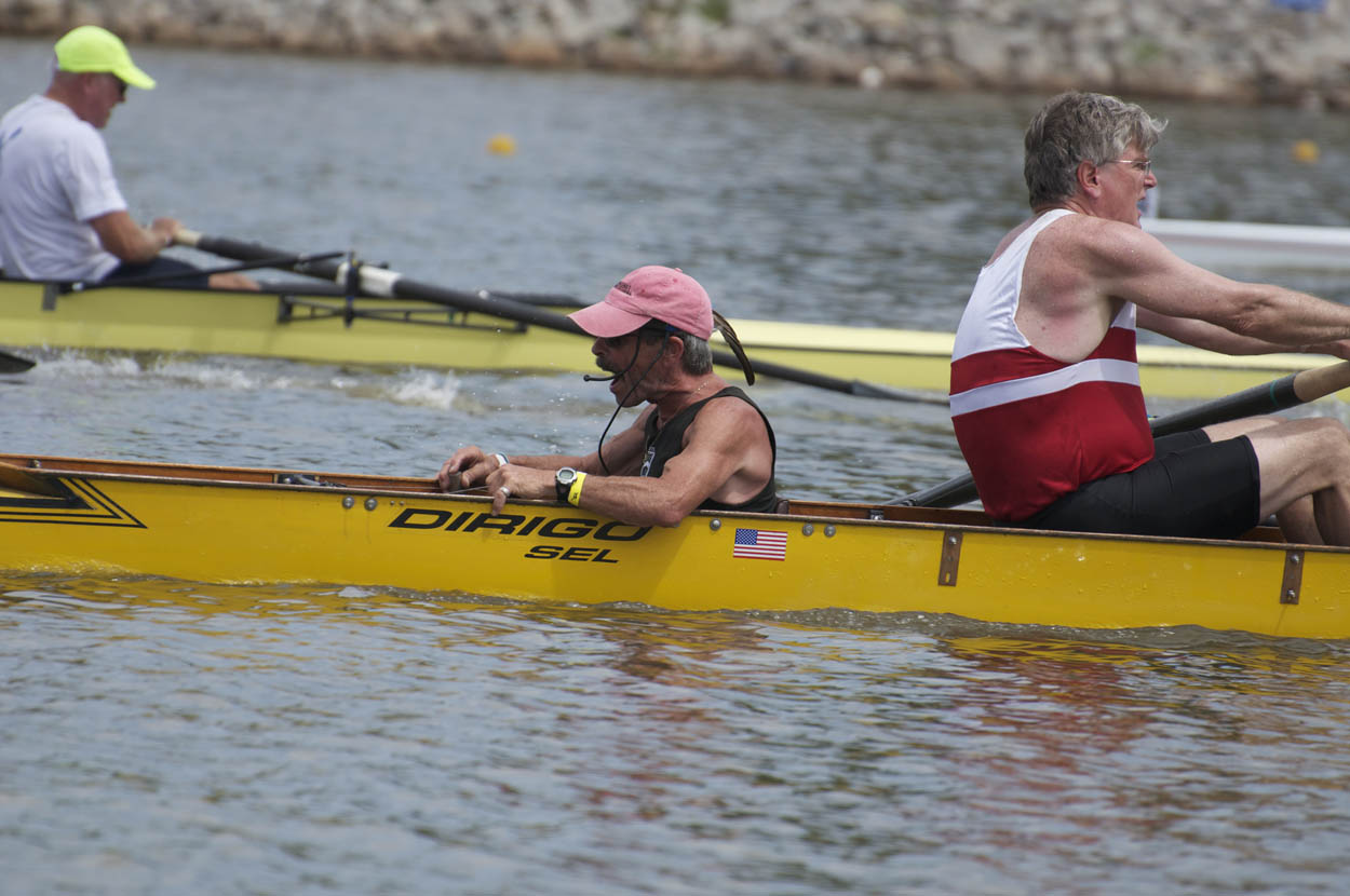 a man in red shorts and pink hat sitting on a yellow rowing boat