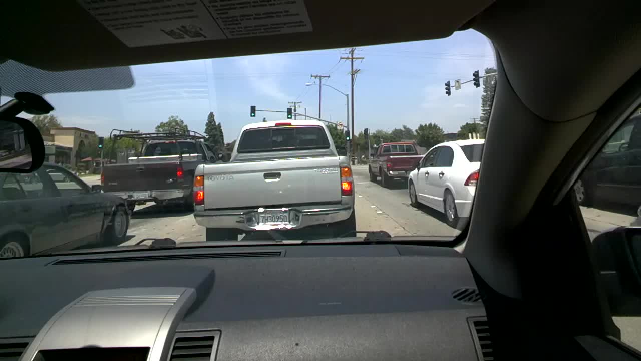 three vehicles driving down the street through traffic signals
