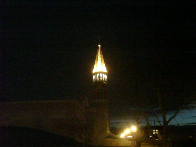 a tall building sitting on top of a hill under a street light