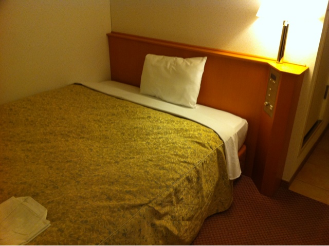 this el room has a bed, nightstand, and phone
