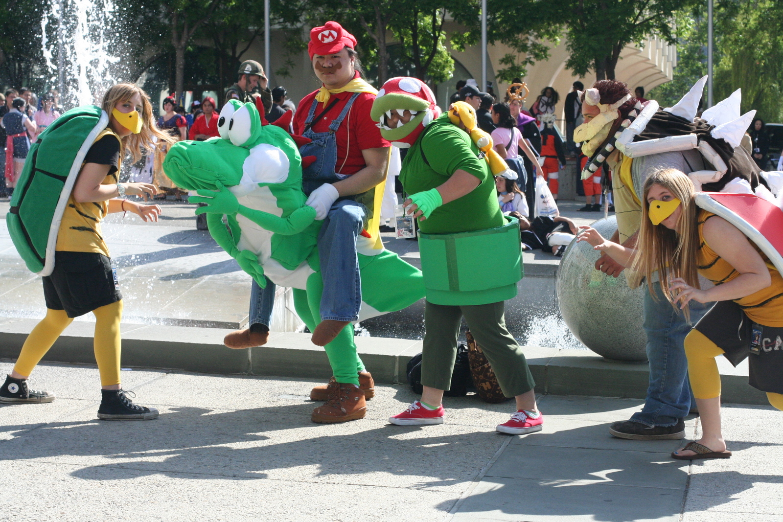 a group of people in costume stand near a fountain