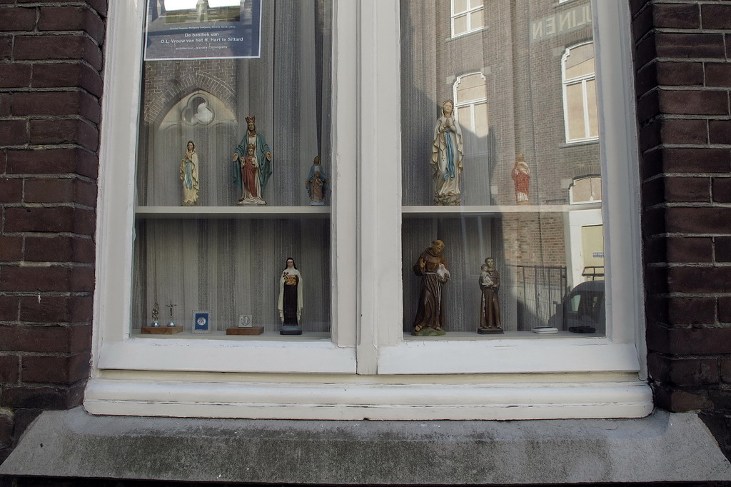 a pair of stained glass windows with statues in the glass