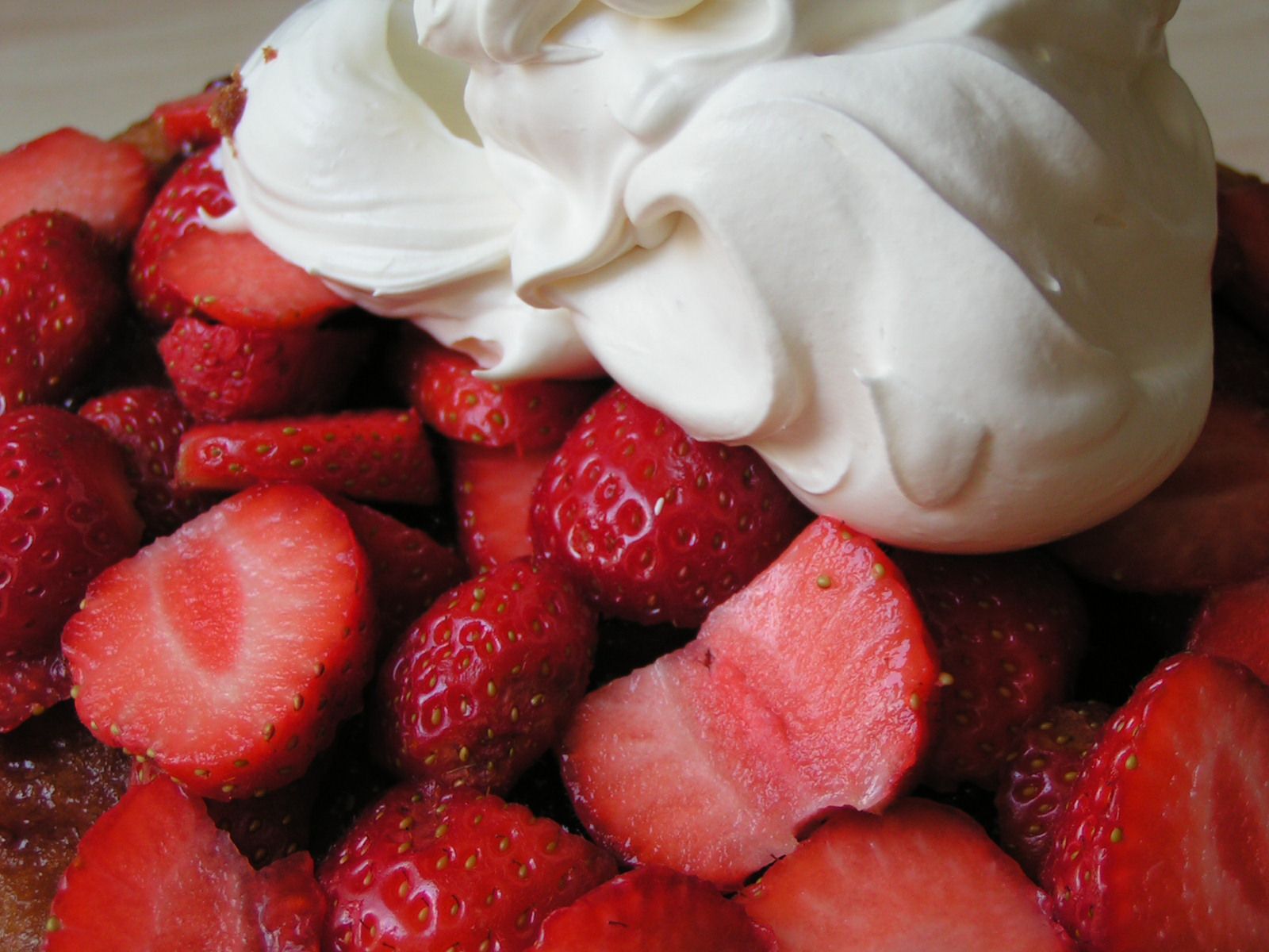 a cake with whipped cream, strawberries, and some creme