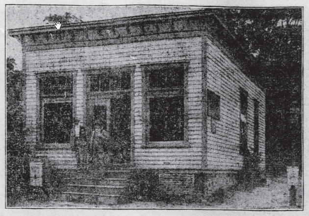 an old image of a person outside a small house