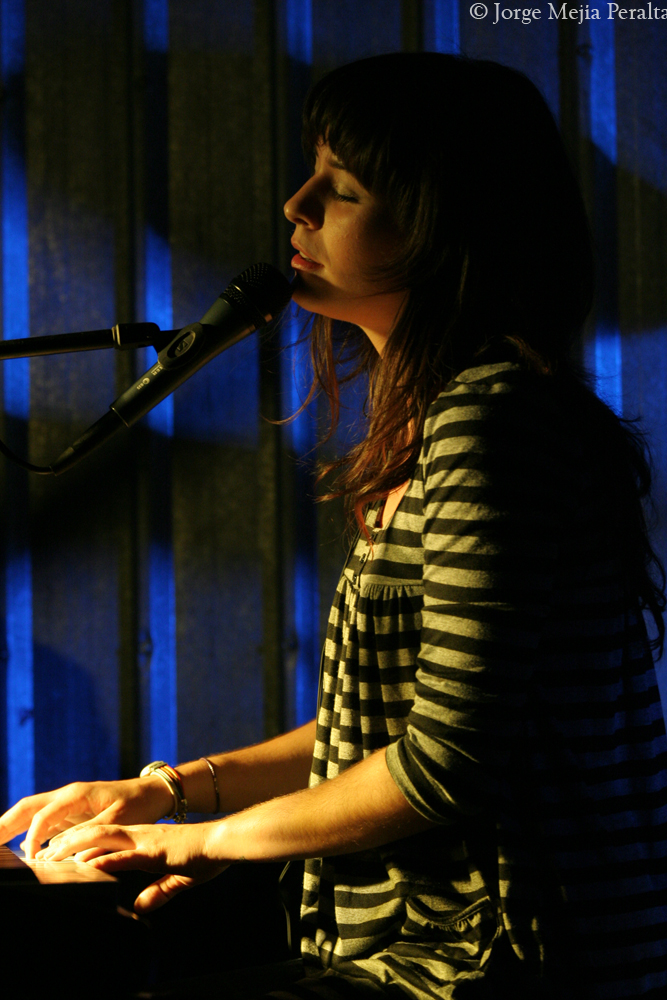 a woman sitting in front of a microphone on top of a keyboard