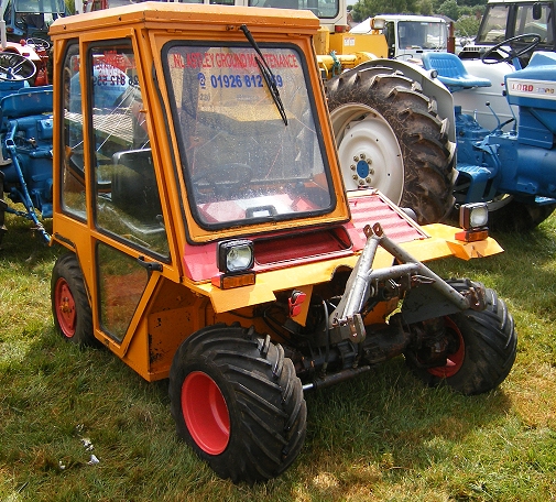 a tractor with a front tire sitting in grass