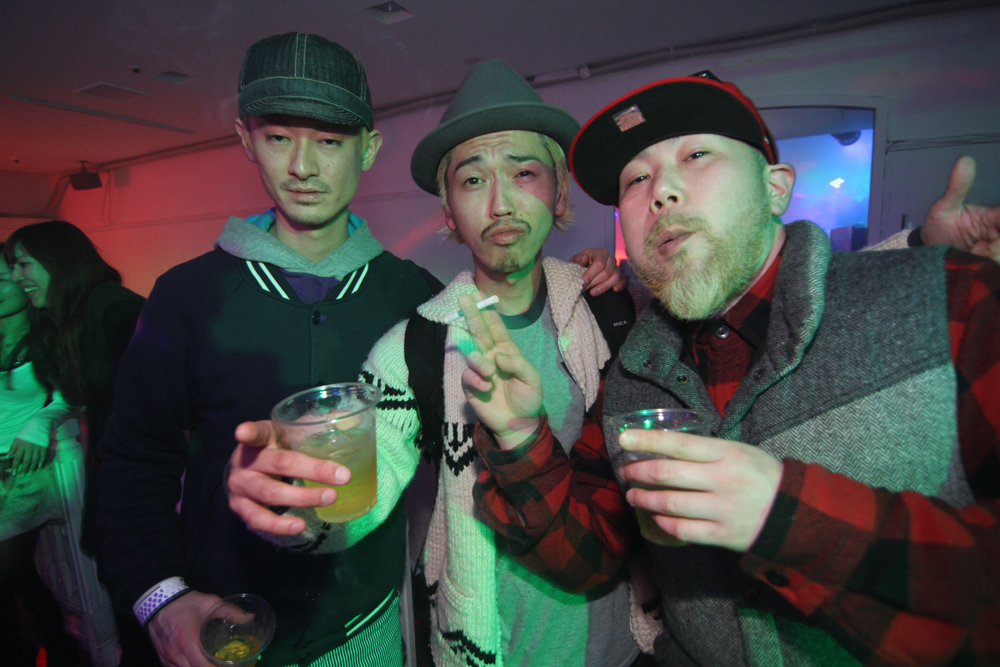 three men with cold drinks in hand pose for the camera