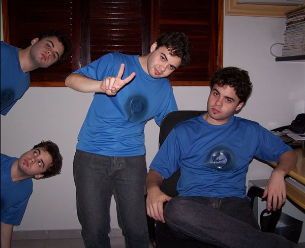 four boys sitting in a chair one pointing at soing