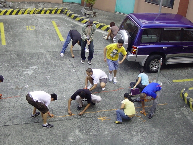 men working together in an empty parking lot