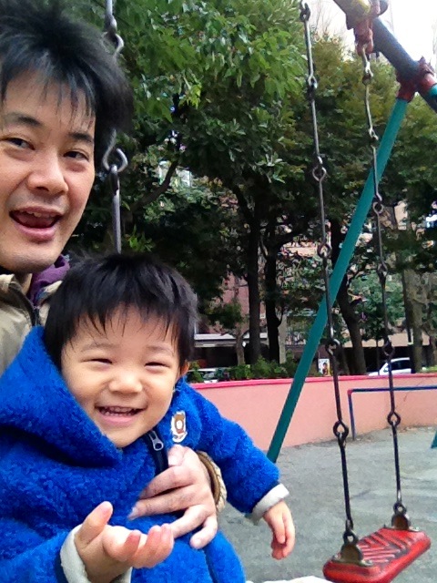 the man and young child are having fun on a swing