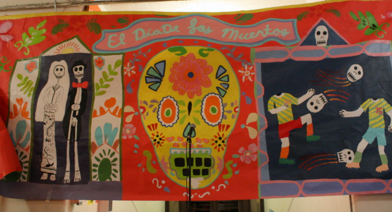 a display of colorful hand made cloths with a skull and flower