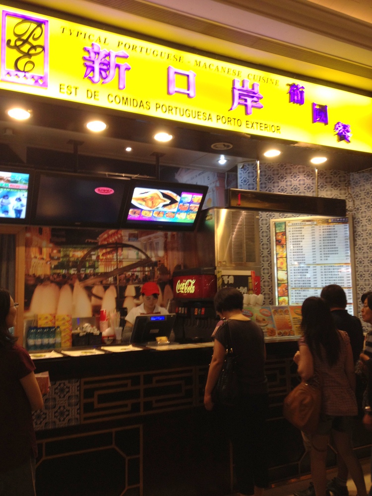 people are gathered in line to get food at a restaurant