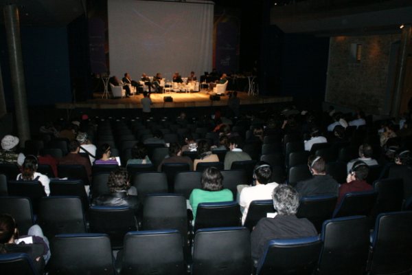 a group of people sit on top of chairs in front of an audience