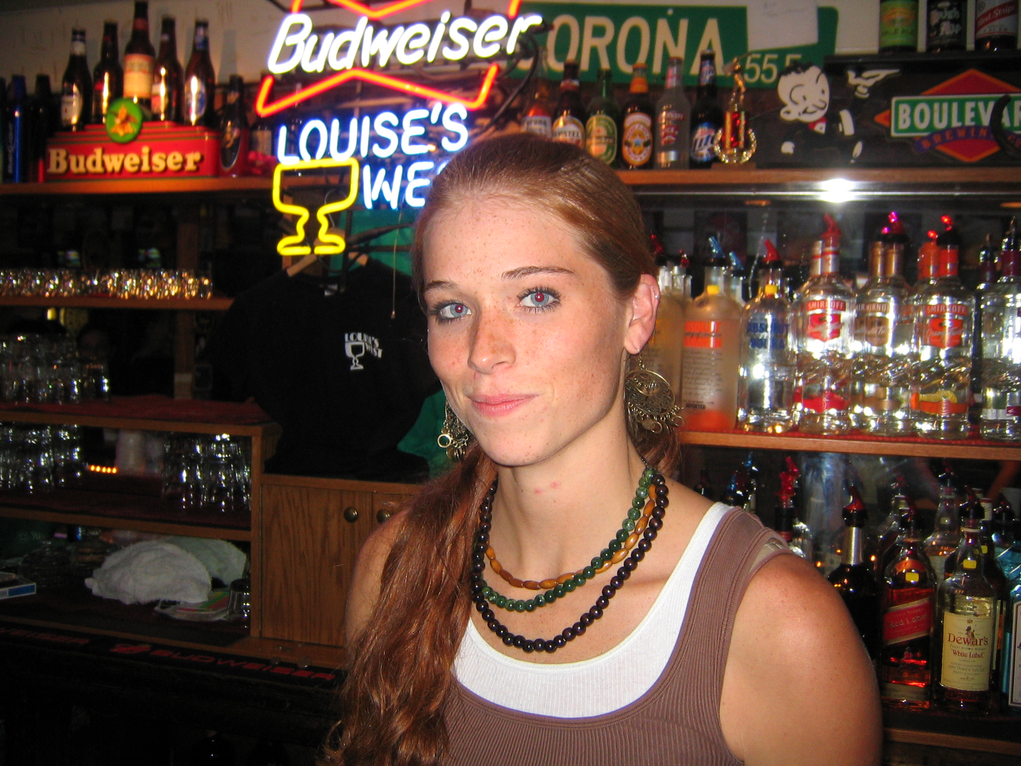 young woman with id in front of shelves of liquor