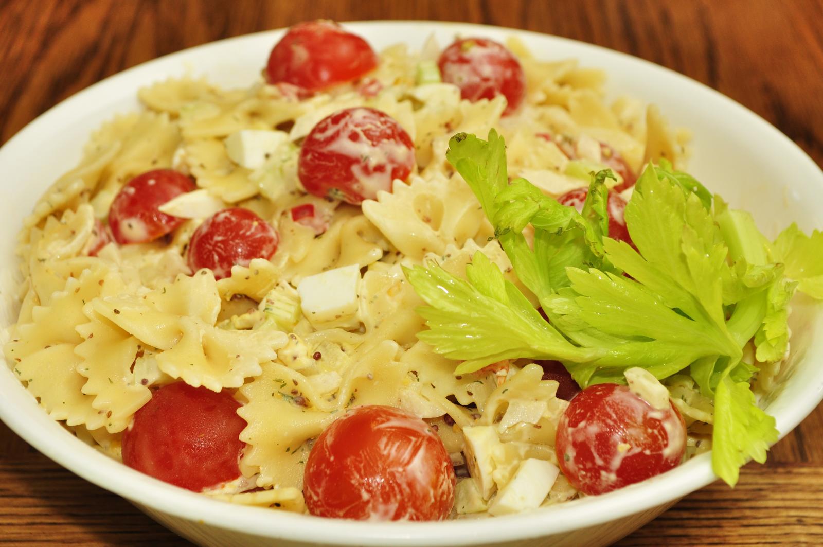 this salad has pasta, tomatoes, lettuce and cheese in it