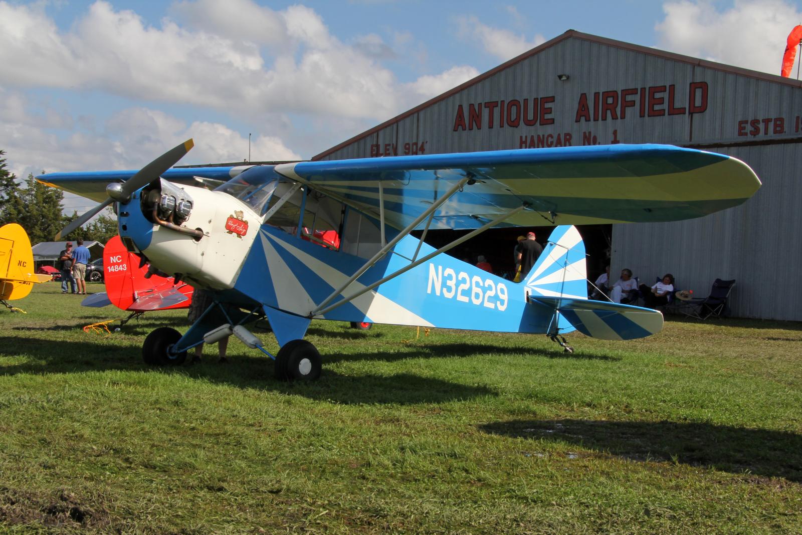 an antique biplane parked outside of a museum