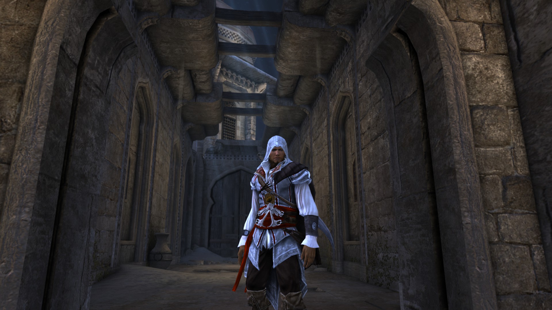 a man dressed in medieval clothing and a white hood stands among stone archways