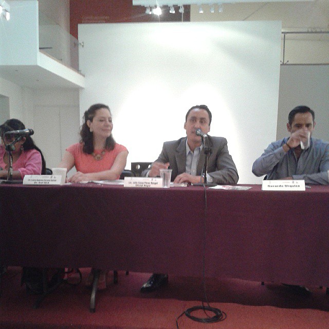 four people sitting at a table with microphones