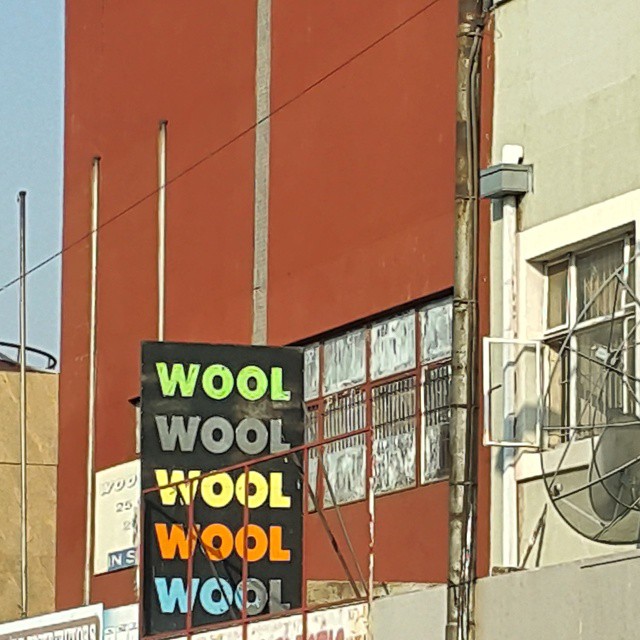 a business sign hanging on a building in an industrial setting
