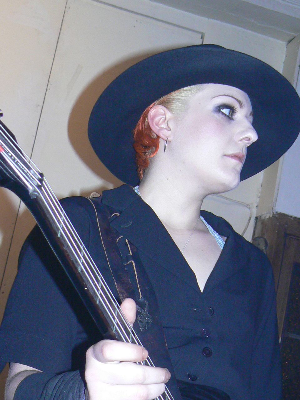 a girl in a hat playing an electric guitar